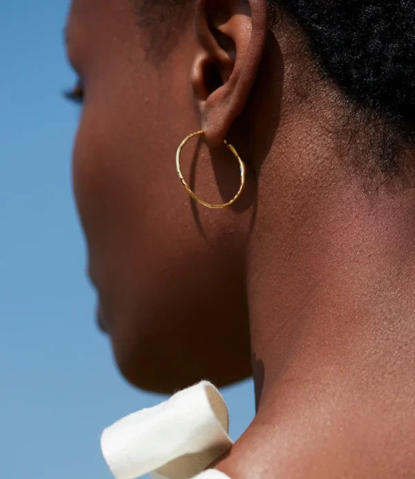 Close-up of ear wearing gold hoop earring