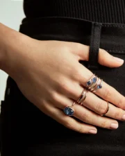 Hand with blue gemstone rings on hip