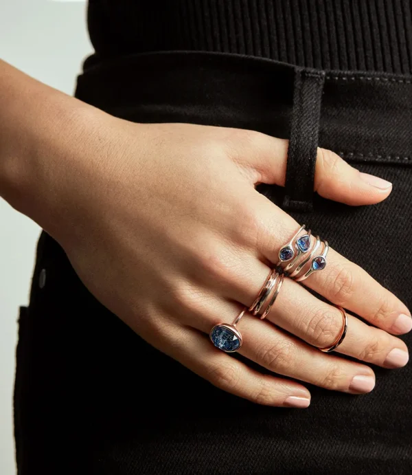 Hand with blue gemstone rings on hip