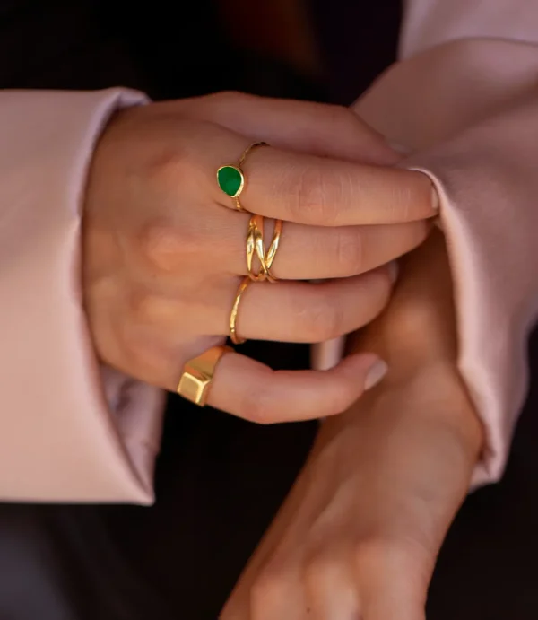 Hand with gold rings and green gemstone