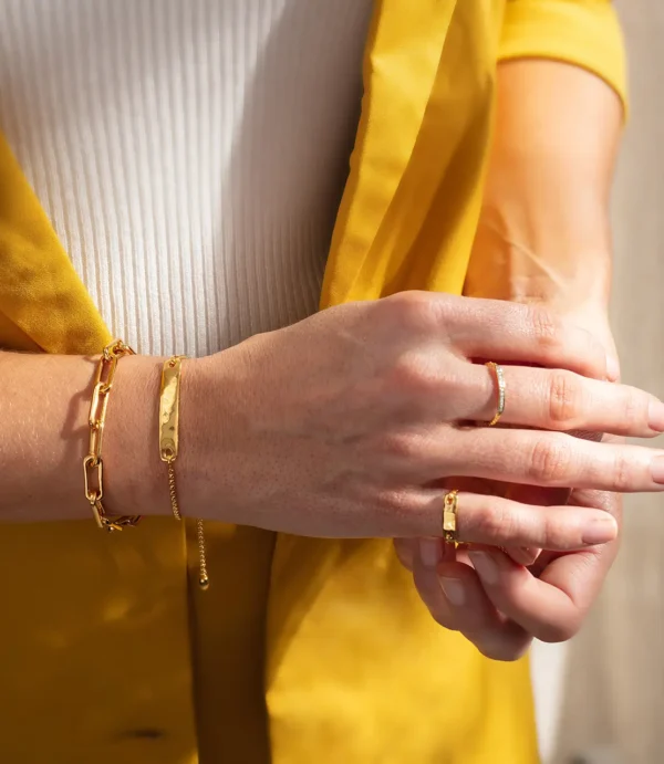 Hands wearing gold rings and bracelets