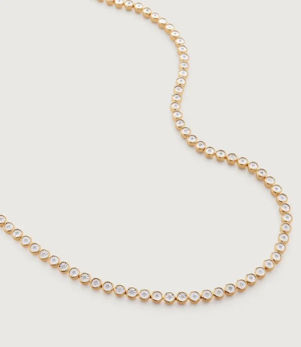 Gold bezel-set diamond necklace on white background