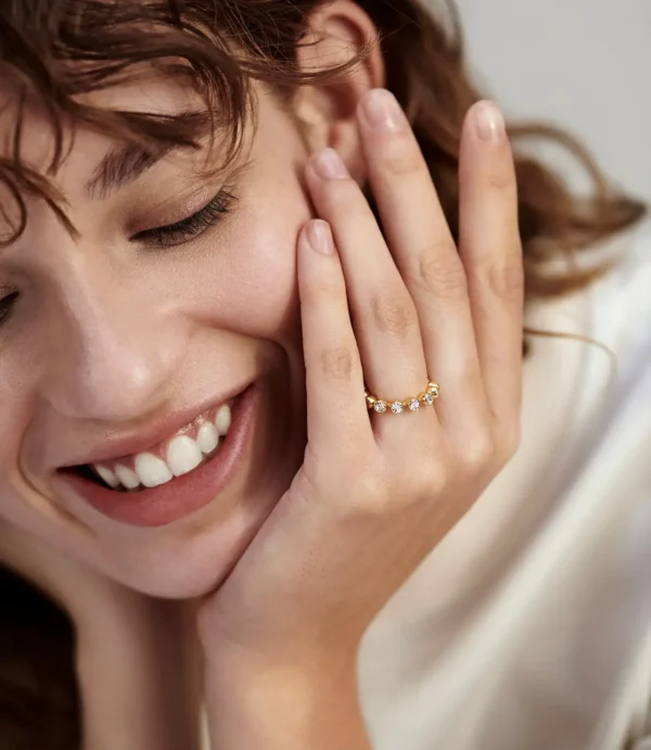 Close-up smiling woman wearing gold diamond ring