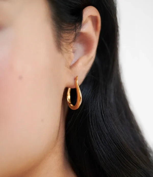 Close-up of ear with gold hoop earring