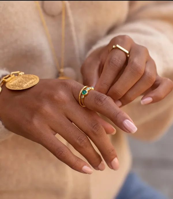 Hands wearing gold rings and bracelet