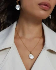 Close-up of neck wearing pearl necklace and earrings