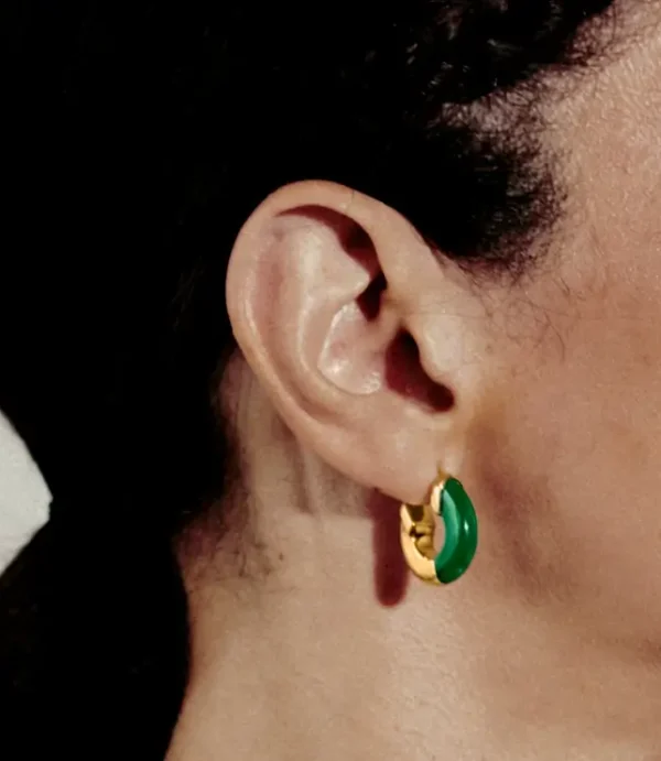 Close-up ear with green and gold hoop earring