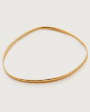 Thin gold oval bangle on white background