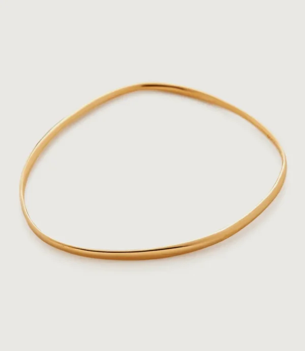 Thin gold oval bangle on white background