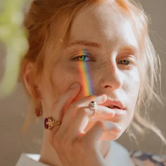 Close-up of woman with rainbow on face