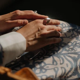 Hands resting with ornate signet ring
