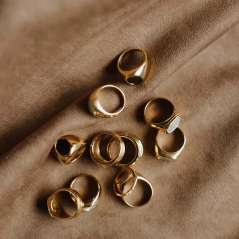 Gold rings scattered on brown fabric